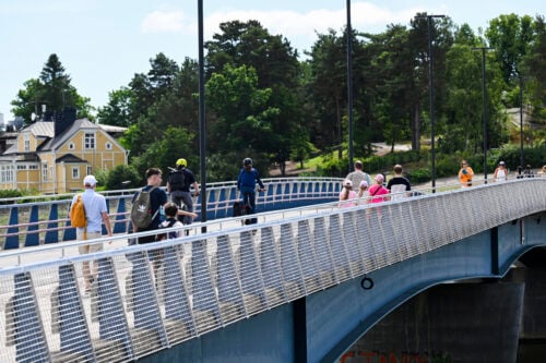 Ihmisiä ylittämässä Korkeasaarensiltaa Helsingissä 26. kesäkuuta.