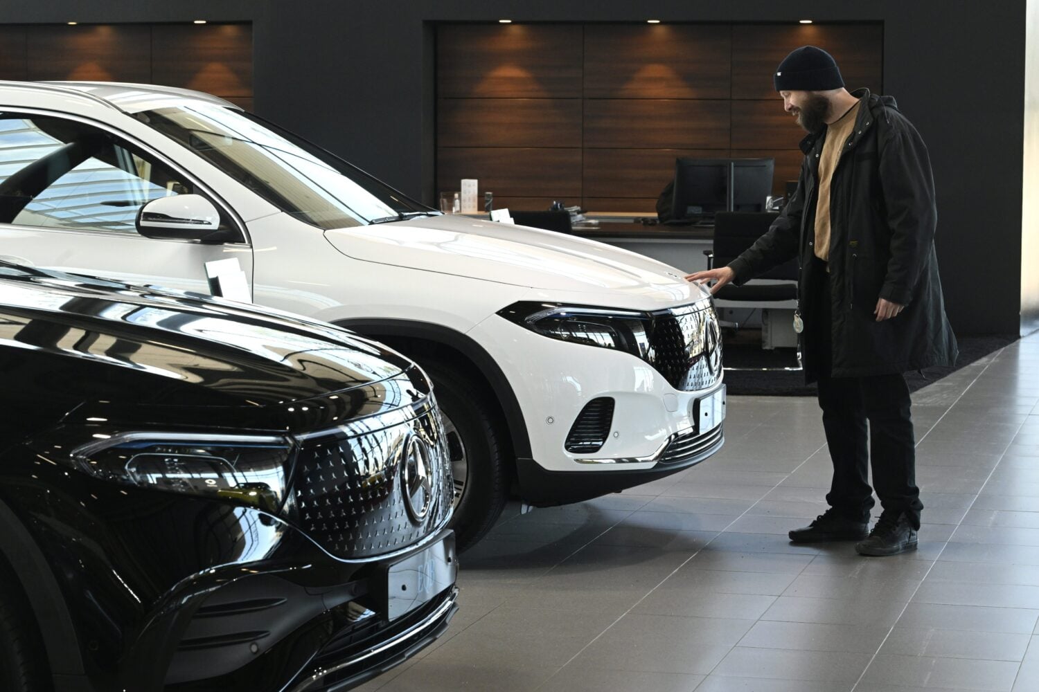 Sähköautoja ja asiakas automyymälässä