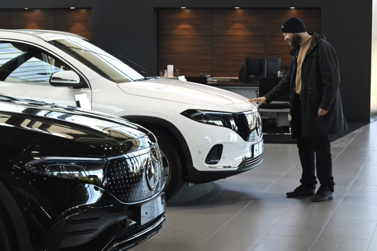 Sähköautoja ja asiakas automyymälässä