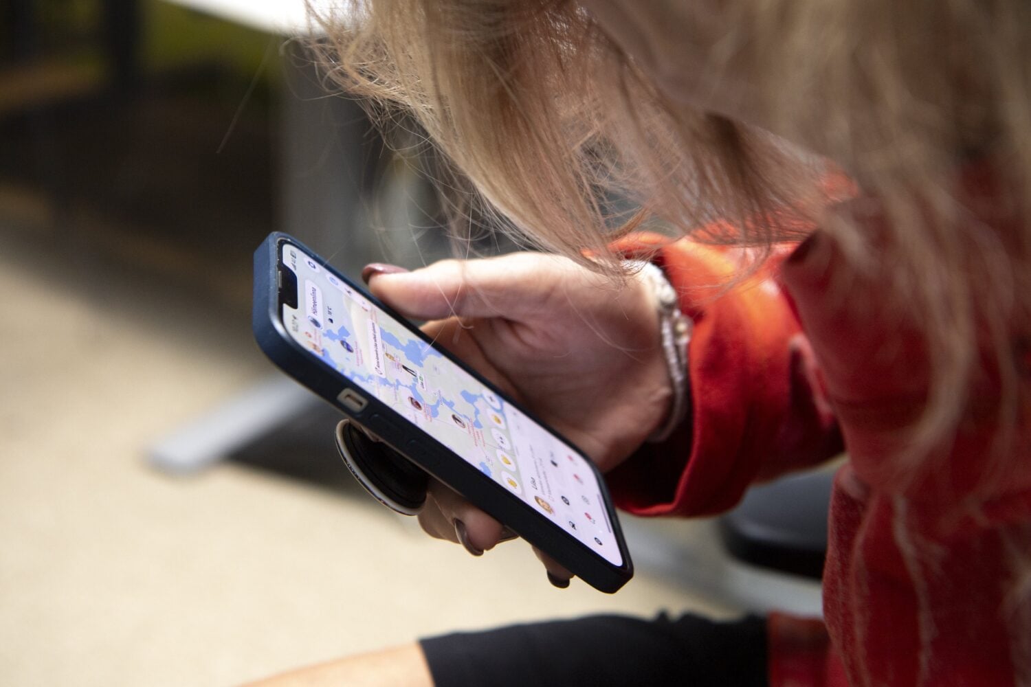 Henkilö tutkimassa Snapchat-sovelluksen karttaa. LEHTIKUVA / ELSA PAAKKINEN