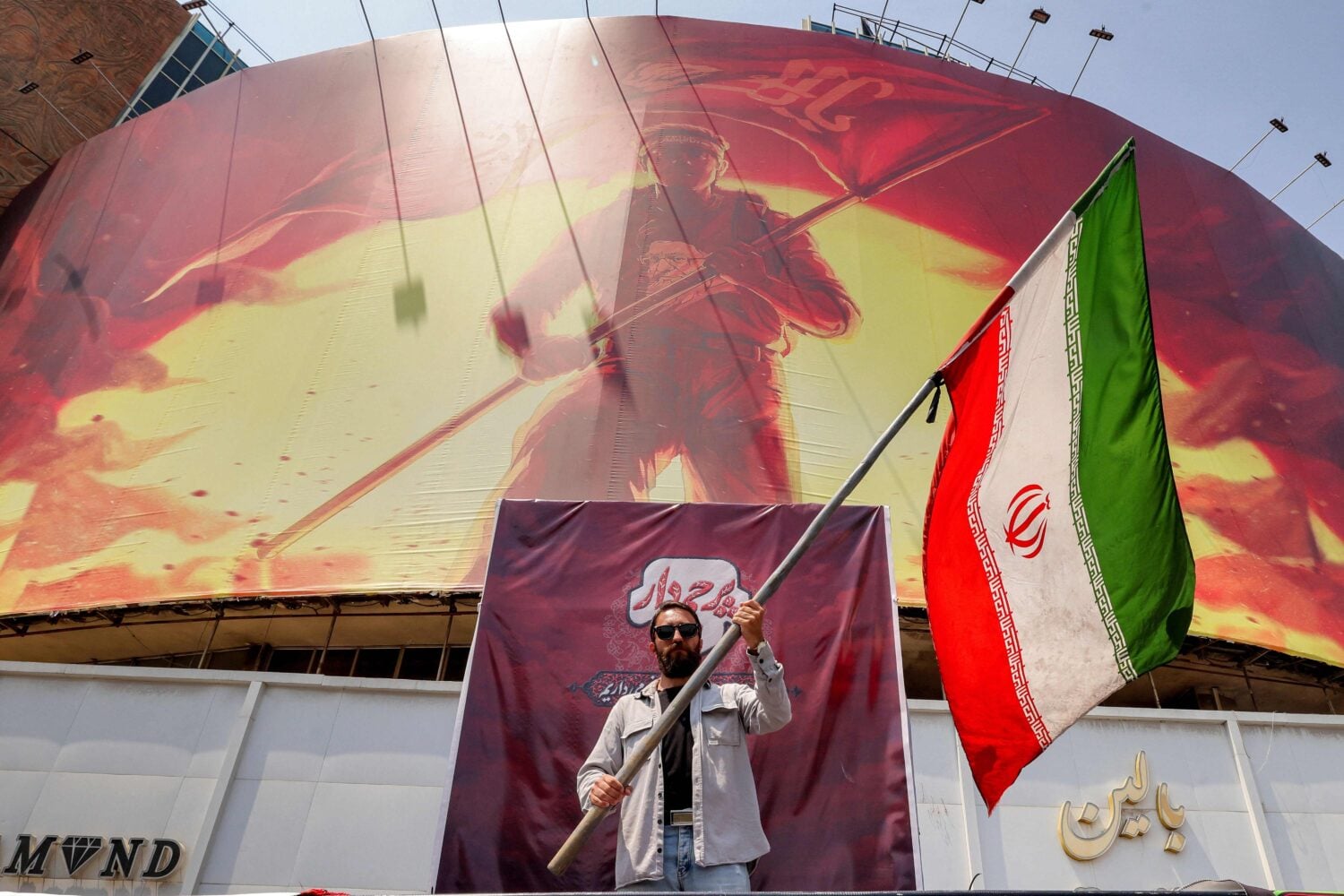 Mies Iranin lipun kanssa Teheranissa. / AFP / LEHTIKUVA / ATTA KENARE