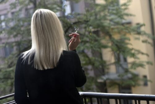 Nainen tupakoi parvekkeelta. LEHTIKUVA / EMMI KORHONEN