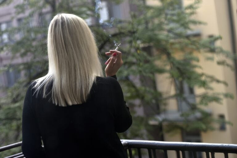 Nainen tupakoi parvekkeelta. LEHTIKUVA / EMMI KORHONEN