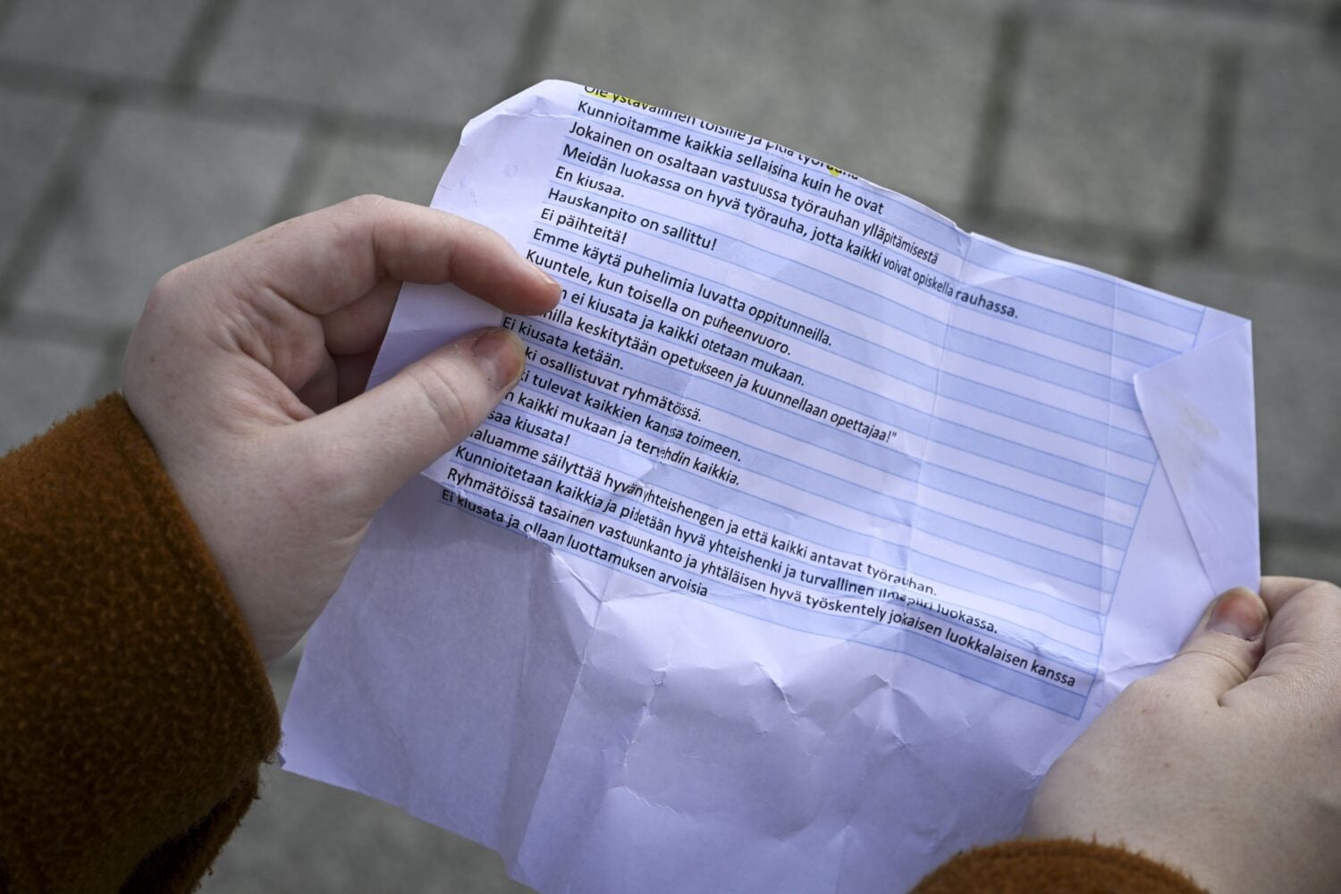 Nuori lukemassa ohjeita koulukiusaamisen ehkäisemiseksi. LEHTIKUVA / EMMI KORHONEN