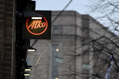 Alkon logo Alkon lippulaivamyymälän ulkopuolella Kampissa Helsingissä 6. marraskuuta 2025. Taustalla näkyy Eduskuntatalo., LEHTIKUVA / EMMI KORHONEN
