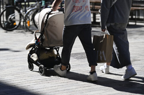 Pariskunta kävelyllä lastenrattaiden kanssa Helsingin Punavuoressa keväällä.