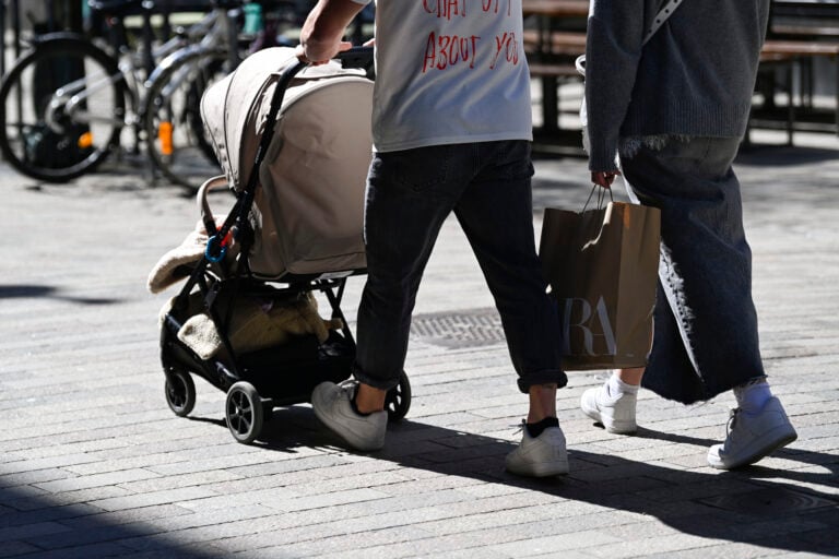 Pariskunta kävelyllä lastenrattaiden kanssa Helsingin Punavuoressa keväällä.