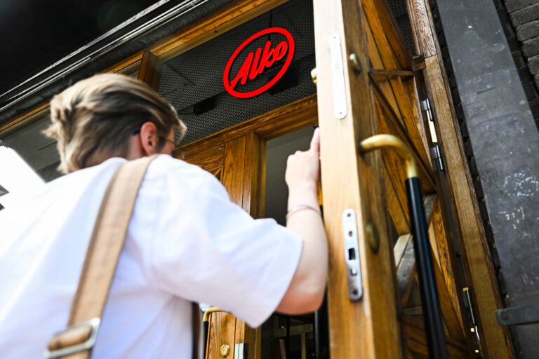 Henkilö juomaostoksilla Alkossa Helsingissä 23. kesäkuuta.
