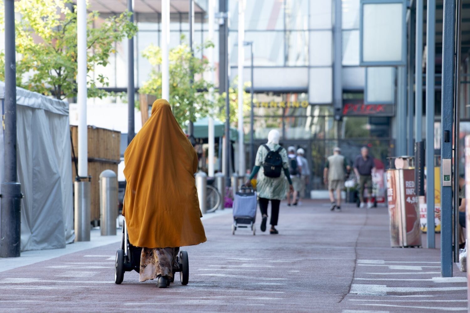 Ihmisiä Itäkeskuksen Tallinnanaukiolla Helsingissä kesällä 2025.