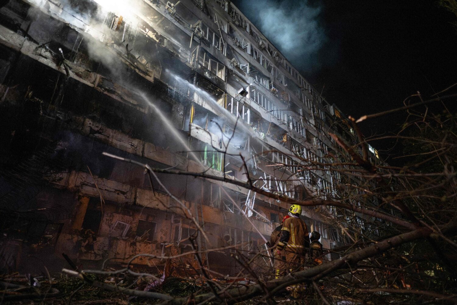 Ukrainian firefighters extinguish a blaze at the site of a Russian missile strike at an apartment building in Kyiv on October 14, 2026. / AFP / LEHTIKUVA / GENYA SAVILOV