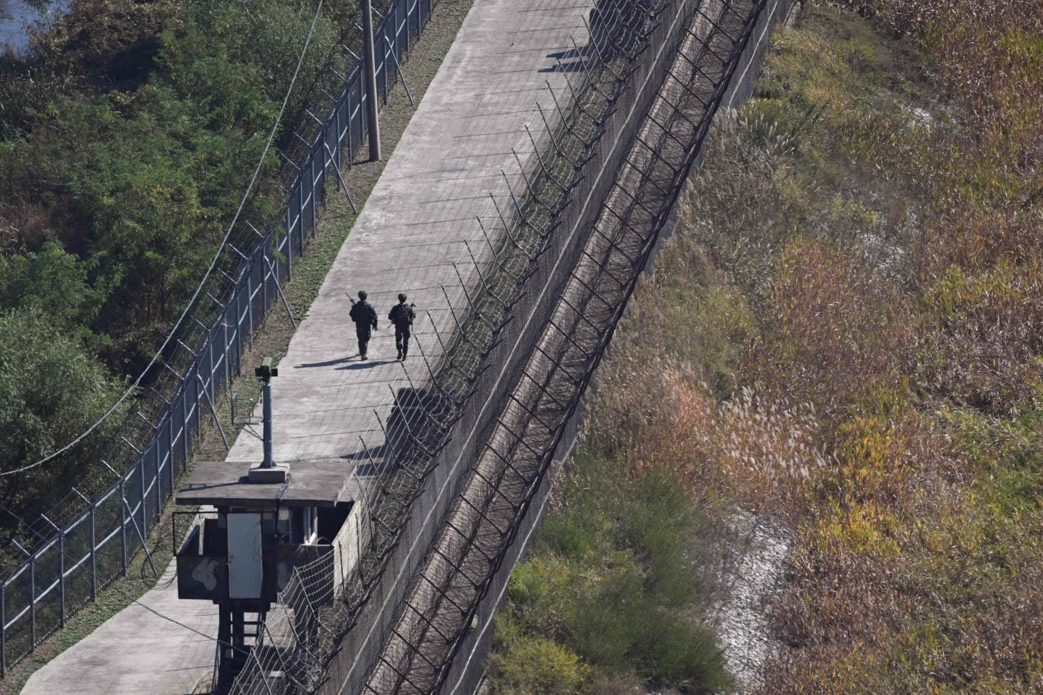 South Korean soldiers patrol along a military fence on the south side of the Demilitarised Zone (DMZ) dividing the two Koreas. / AFP / LEHTIKUVA / JUNG YEON-JE