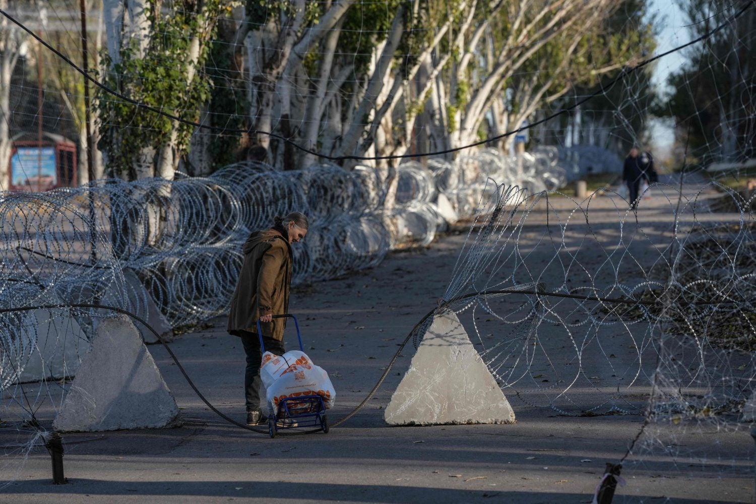 Local residents walking along a street protected with barbed wire and anti-drone nets in the frontline city of Kramatorsk, Donetsk region Ukraine. AFP PHOTO/LEHTIKUVA/ IRYNA RYBAKOVA / PRESS SERVICE OF THE 93RD KHOLODNYI YAR SEPARATE MECHANIZED BRIGADE